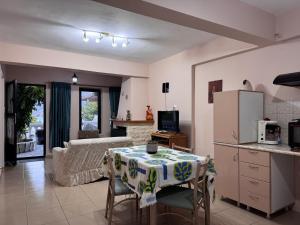 a kitchen and living room with a table and a refrigerator at Mina Apartments in Poros