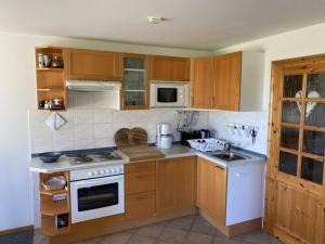 eine Küche mit Holzschränken und einem weißen Herd mit Backofen in der Unterkunft Ferienwohnung Nr 01 EG in Born + 15 Fotos
