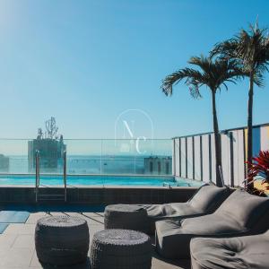 vistas a una piscina con sillas y palmeras en Skylux by RNC Flats, en Río de Janeiro