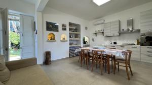 Una cocina con una mesa y sillas en una habitación. en Villetta Capilungo by Salento Affitti, en Capilungo