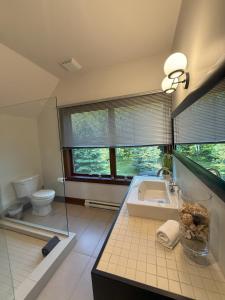 ラック・シュペリュールにあるChalet Inukshuk Luxury Log Cabin with Spa Lake View and Club Access near Mont Tremblantの洗面台とトイレ付きのバスルーム +48枚の写真