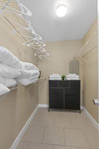 オースティンにあるCozy Luxury Retreat - Modernのベッドと白い枕が置かれたドレッサーのある寝室