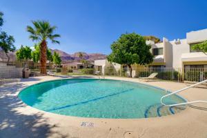 a swimming pool in a yard with trees and a building at Furnished Patio and Mtn View Palm Desert Retreat in Palm Desert