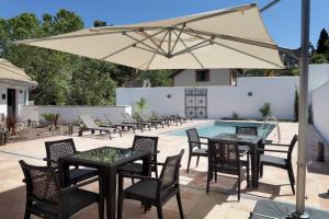 a patio with tables and chairs and an umbrella at Áurea Washington Irving by Eurostars Hotel Company in Granada