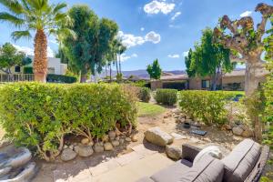 a garden with a couch and trees and a building at Furnished Patio and Mtn View Palm Desert Retreat in Palm Desert