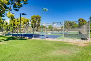 a tennis court with two tennis courts behind a fence at Furnished Patio and Mtn View Palm Desert Retreat in Palm Desert