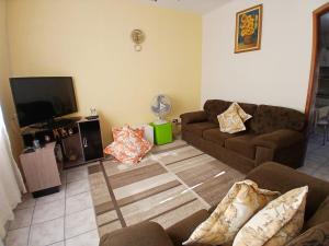 サン・ベント・ド・サプカイーにあるCasa Descanso São Bento Sapucaíのソファ2脚と薄型テレビのあるリビングルーム