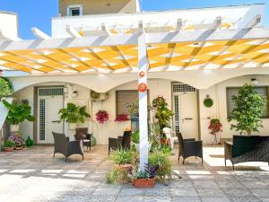 a patio with a yellow and white pergola at A casa di Pietro Quattro in Leporano