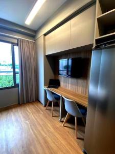 a room with a desk with chairs and a laptop on it at Apartamento Aconchegante na Vila Mariana in Sao Paulo