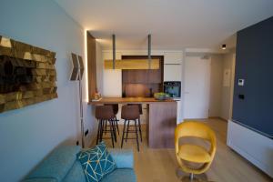 a living room and kitchen with a couch and chairs at Boutique Spa Studioapartment IV in Opatija