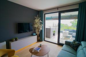 a living room with a blue couch and a television at Boutique Spa Studioapartment IV in Opatija
