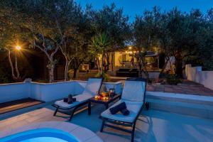 a patio with two chairs and a table next to a pool at Holiday home Stari Grad - Insel Hvar 6341 in Stari Grad
