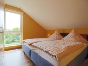 a bed in a room with a large window at FeWo Golfblick in Wittenbeck +1 photo