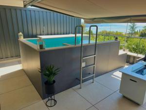 a swimming pool on a balcony with a tub at Boutique Spa Studioapartment IV in Opatija
