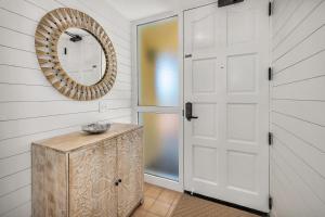 a bathroom with a mirror and a wooden door at King and Prince #478 in Harrington