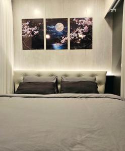a bedroom with a bed with four pictures on the wall at Free Airport Pick Up ! 12th Floor Cozy Studio Room, 5 mins walk to IconSiam & BTS in Bangkok