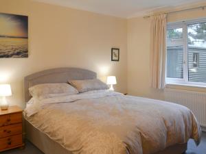 a bedroom with a bed with two lamps and a window at Quiet Ways in Portinscale +6 photos