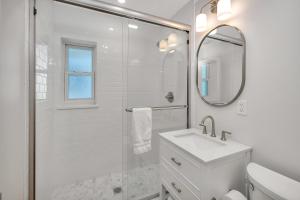 Un baño blanco con lavabo y espejo. en 588 Demere-3, en Saint Simons Island 31 fotos más