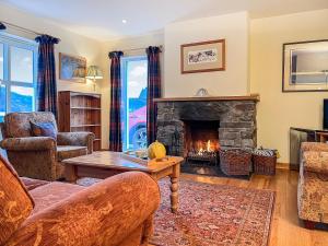 a living room with a couch and a fireplace at The Old Post Office - Cottage in Arnisdale