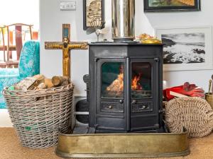 a wood stove in a living room with a cross at Willow Cottage in St Just +32 photos