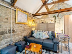 a living room with a blue couch and a table at The Old Wash House in Amble