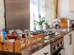 a kitchen counter with a sign that reads the oil kitchen home at The Old Wash House in Amble +10 photos