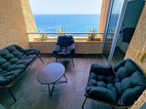 a balcony with two couches and a view of the ocean at Live Tabaiba Maritime in Tabaiba
