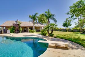 a swimming pool with a surfboard in front of a house at Luxe Scottsdale Home with Horse Stables and Pool! in Scottsdale
