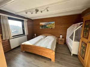 a bedroom with a bed in a room with wooden walls at Haus 44 Feldblick Fewo 1 oben in Arrach +2 photos