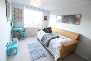 a bedroom with a bed and a desk and a window at Comodo Departamento Cercano al Centro y el Lago in Puerto Varas