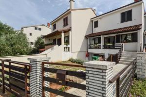 a house with a wooden fence in front of it at Studio Apartment Pula near Sea 2 in Vintijan