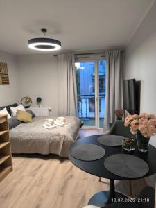 a living room with a bed and a table at Apartments Poznań City LOFT in Poznań
