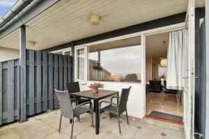 a patio with a table and chairs on a balcony at Lovely Holiday Apartment Consumption Included in Allinge