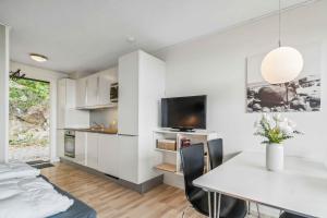 a living room with a table and a tv at Lovely Holiday Apartment Consumption Included in Allinge +17 photos