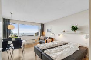 a bedroom with a bed and a table and chairs at Lovely Holiday Apartment Consumption Included in Allinge