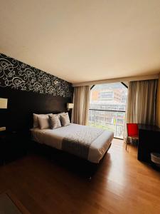 a bedroom with a bed and a large window at Hotel Silver Javeriana By Hospedium Bogota in Bogotá
