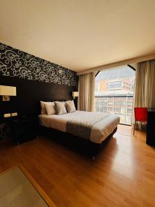 a bedroom with a large bed and a large window at Hotel Silver Javeriana By Hospedium Bogota in Bogotá