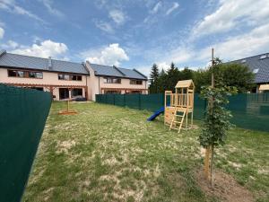 a yard with a playground in front of a house at Vily Pod Vyhlídkou in Velké Losiny