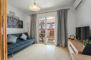 a living room with a blue couch and a television at Parque Carolina 207 in Costa Del Silencio