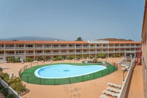 a resort with a large swimming pool in front of a building at Parque Carolina 207 in Costa Del Silencio