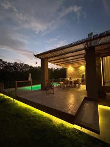 a backyard patio with a table and a pergola at night at Casa de Campo con Piscina, BBQ y Naturaleza Cañete in Imperial