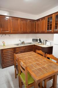 a kitchen with wooden cabinets and a table with chairs at Casa do Areal in Alenquer