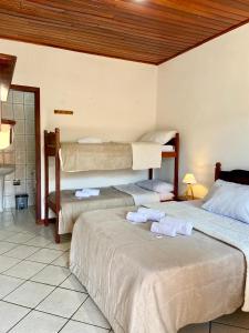 a bedroom with two beds with towels on them at Pousada Verona Paraty in Paraty