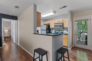 a kitchen with a counter and two stools at Lux Private Retreat - King Bed in Austin