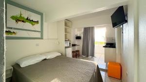 a bedroom with a bed and a tv in a room at Pousada Vila do Navegante in Bombinhas