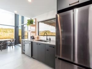 サセックスにあるLuxury Cabin with Private Hot Tub Minutes from Poley Mountain & Sussexのキッチン(ステンレス製の冷蔵庫、テーブル付)