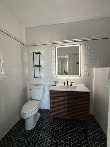 a bathroom with a toilet and a sink and a mirror at Retro-Chic Escape 208 in Klamath Falls