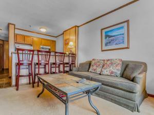 スノーシューにあるTop of the World 213 Ski In Out EZ park ECONOMYのソファとテーブルのあるリビングルーム