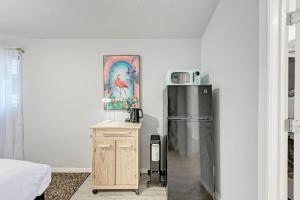 a kitchen with a refrigerator and a table with a microwave at 2 Combined Homes - 2 Private Pools - 16 Guests in Austin +38 photos