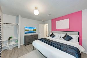 a bedroom with a pink accent wall and a bed at 2 Combined Homes - 2 Private Pools - 16 Guests in Austin